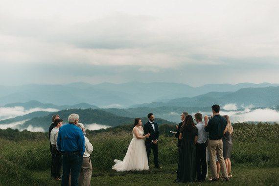 bride and groom on top of a mountain with 10 people attending the wedding