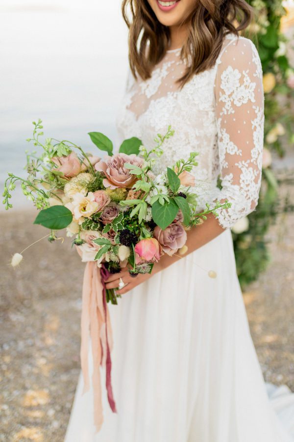 Bride in intricate lace gown and a large bouquet of flowers