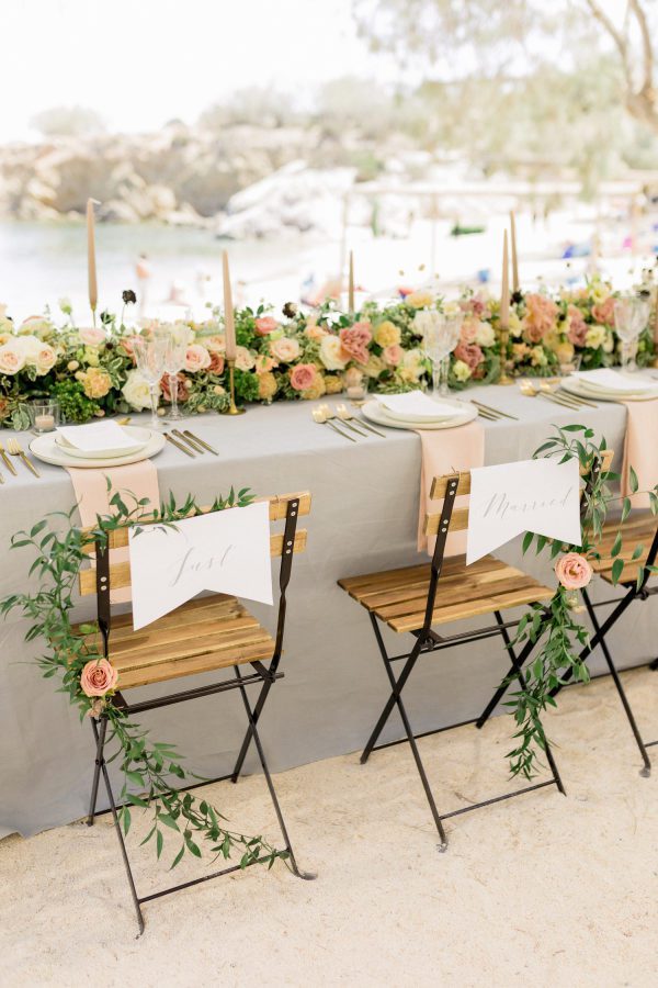 Small table outdoors decorated elaborately with flowers and candles