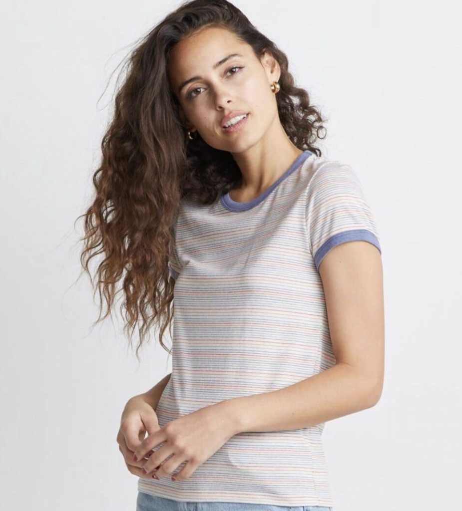 woman with long brown hair wearing a striped t-shirt with blue trim