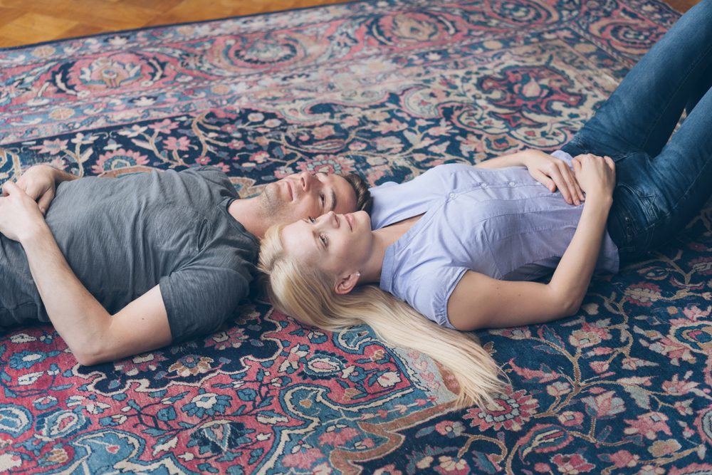 A couple lying on a persian rug