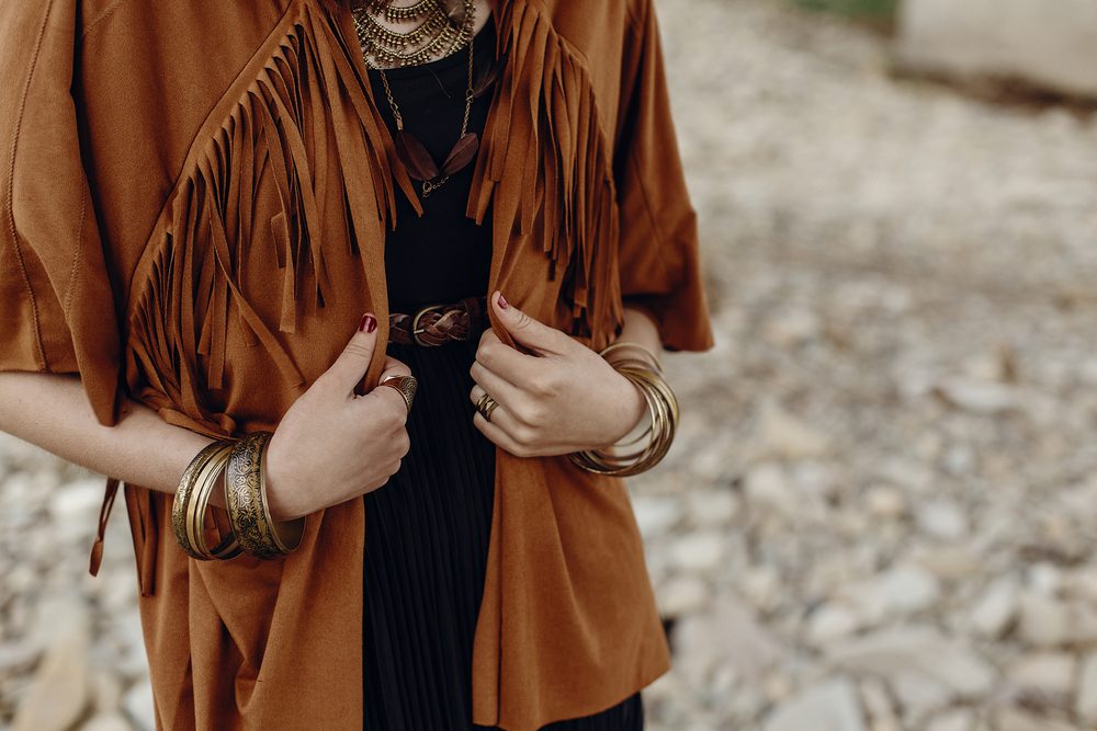 Woman wearing a camel suede jacket with fringe. Have you wondered if suede is durable? Here's how to wear it and keep it clean.